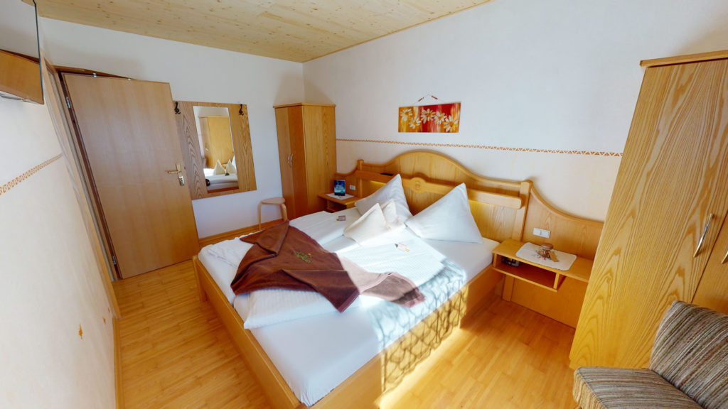 Elternschlafzimmer eines Familienzimmers mit Doppelbett und Holzmöbeln