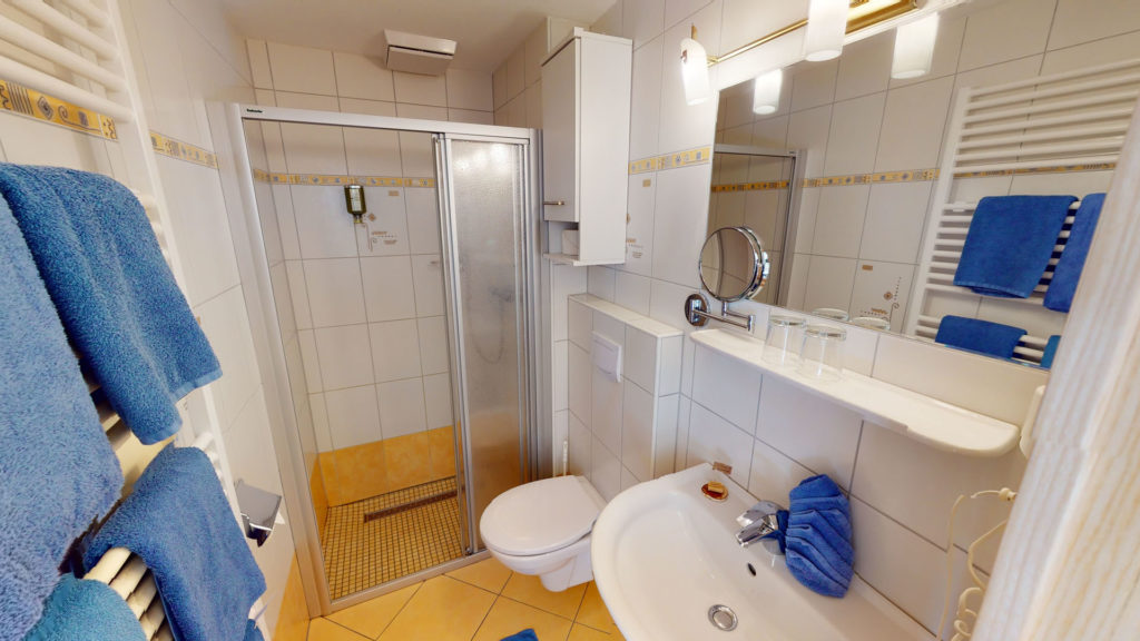 Badezimmer eines Familienzimmers mit Dusche, WC und Waschbecken