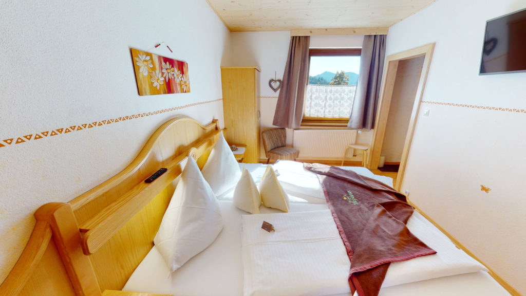 Doppelbett mit Holzrahmen und Bild an der Wand in einem Familienzimmer