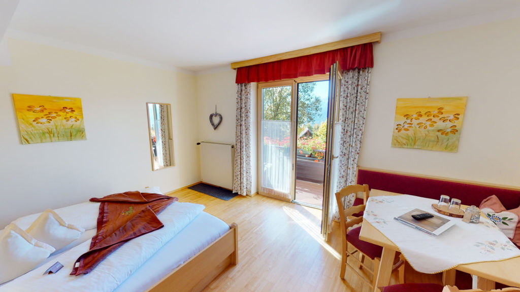 Familienzimmer mit Doppelbett, Sitzecke und Balkontür