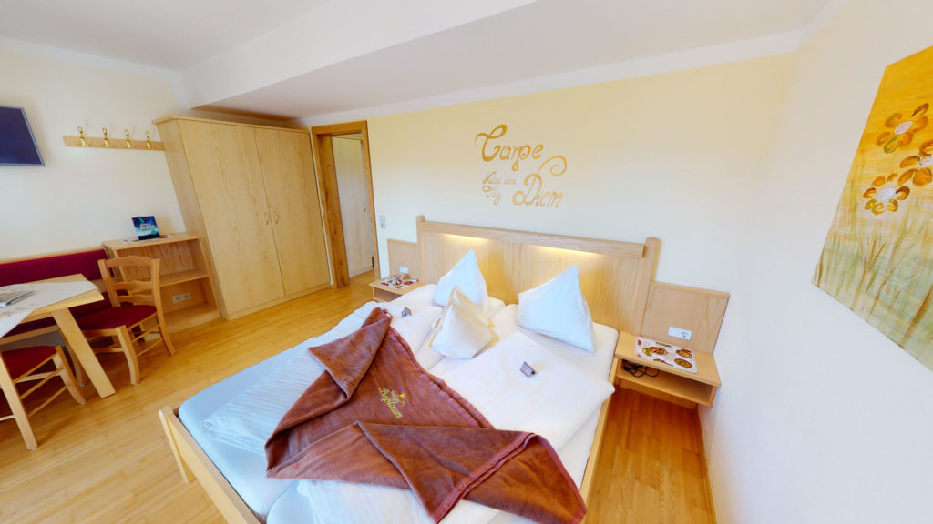 Doppelbett und Tisch im Elternschlafzimmer eines Familienzimmers