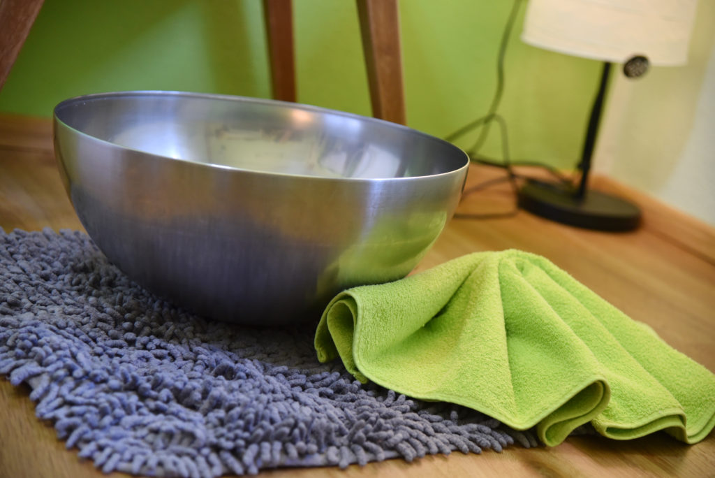Metal bowl and green towel in the Kräuter SPA at Berghotel Presslauer