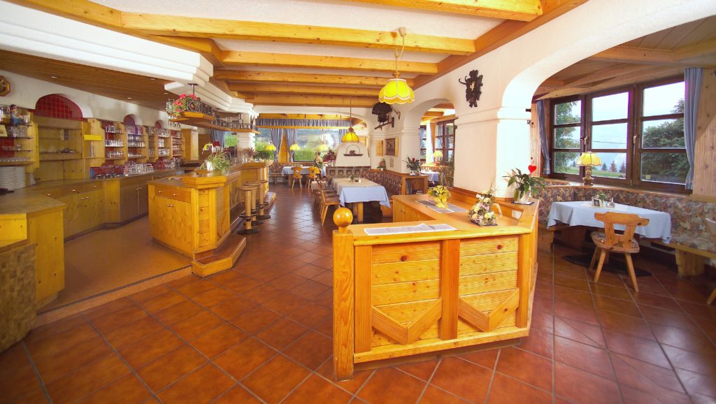 Dining room at Berghotel Presslauer with a wooden bar and laid tables