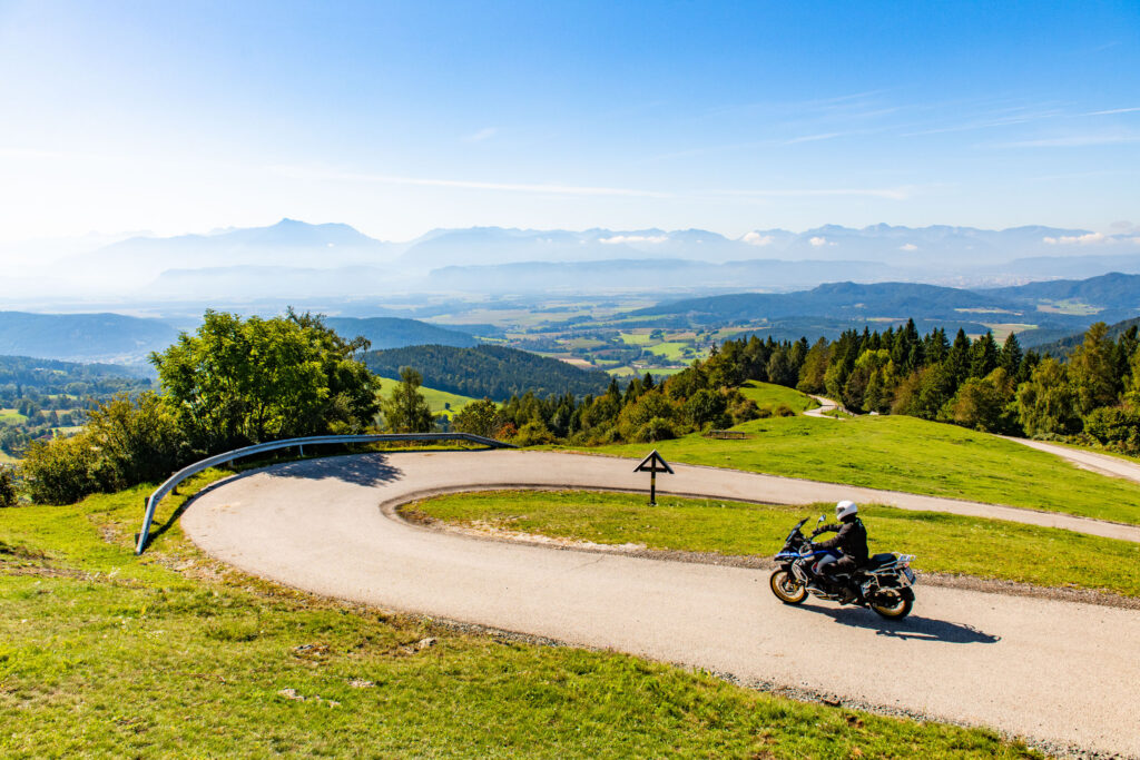 Motorcyclist on a hairpin bend of a mountain road with a view over the valley