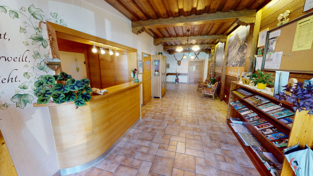Zona d’ingresso del Berghotel Presslauer con reception ed espositore di dépliant