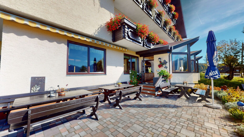Terrasse vor dem Eingang des Berghotels Presslauer mit Tischen und Bänken