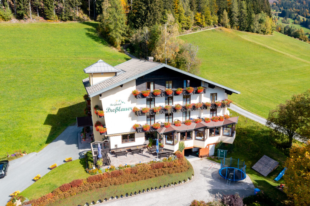 Luftaufnahme des Berghotels Presslauer mit Blumenbalkonen und Garten
