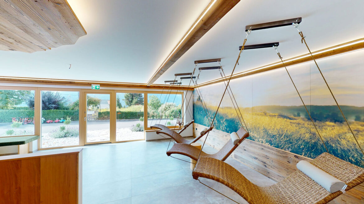 Relaxation room with loungers and large windows in the spa area at Berghotel Presslauer